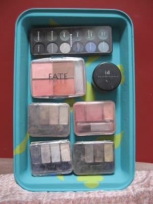 Magnetic make-up organiser showing items of make-up stuck to a metallic tray using ferrite disc magnets