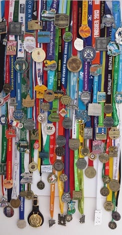 100 running medals attached to a ferrous board with magnets