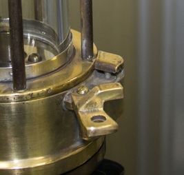 A close up of the magnetic lock on a miners’ lamp showing the catch arm and spring-loaded pin.