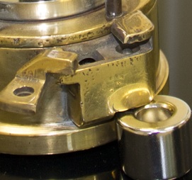 A close up of the magnetic lock on a miners’ lamp showing the catch arm and spring-loaded pin released using a strong magnet.